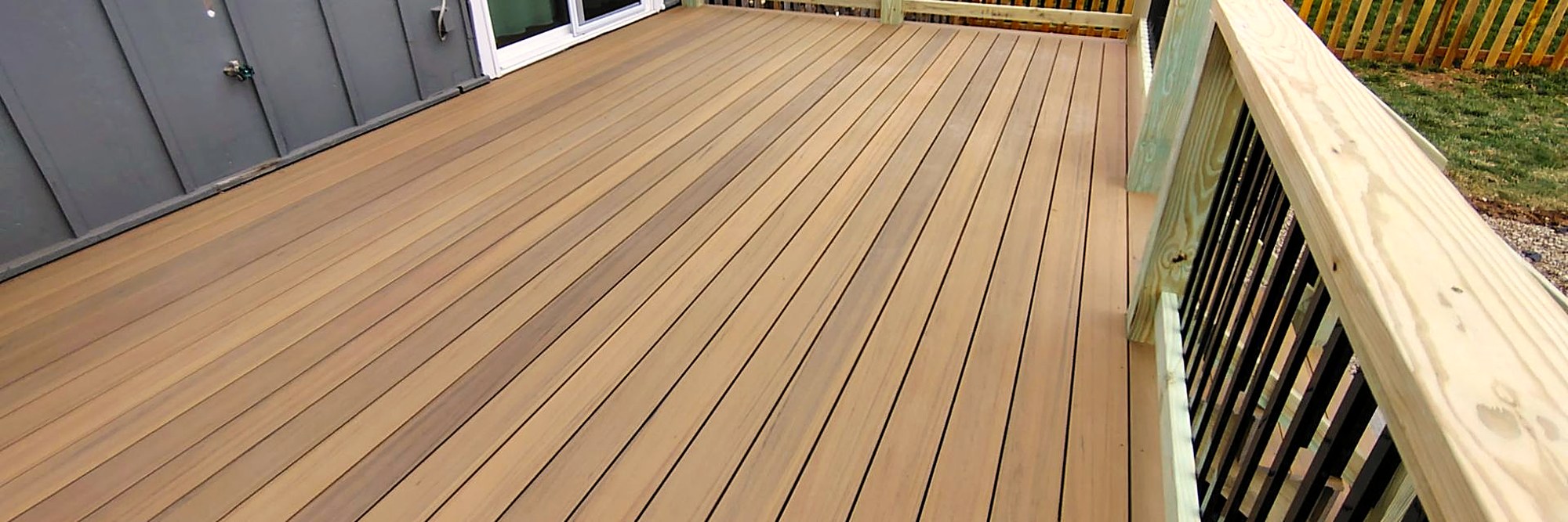 Composite boards running toward a black metal railing.