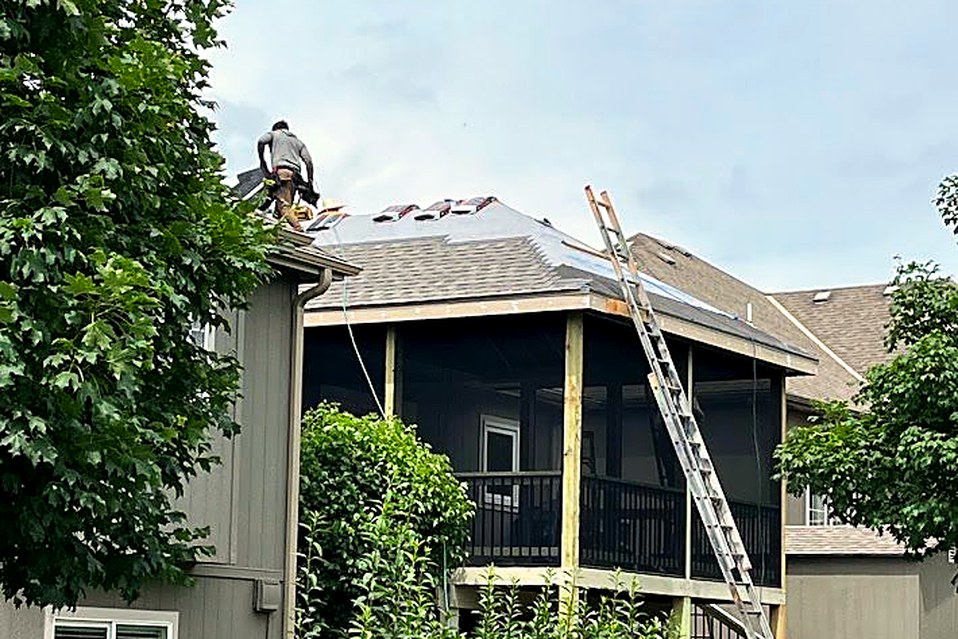A completed deck and stair run on the back of a two-story home.