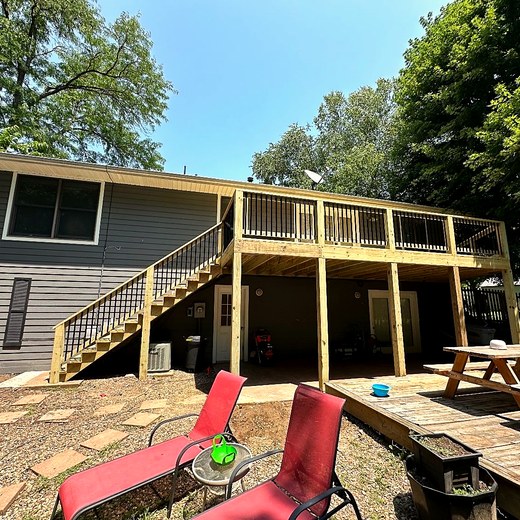 Upper deck with a timber pergola, seen from a lower patio.