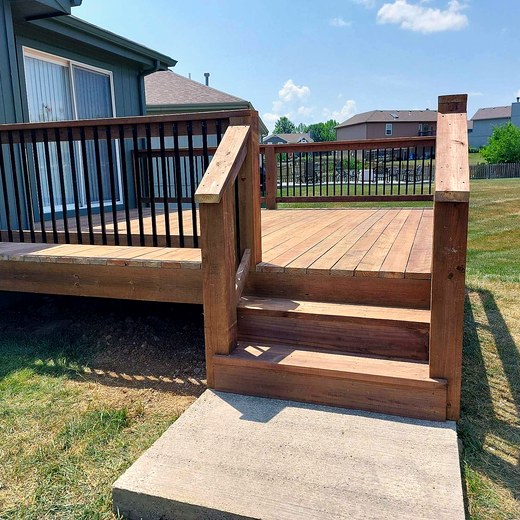 Deck with black aluminum balusters and a stair landing.