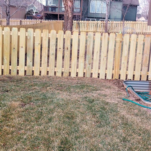 New cedar picket fence along a residential property line.