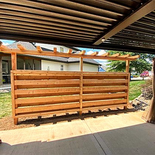 Horizontal slat privacy screen under a timber pergola.