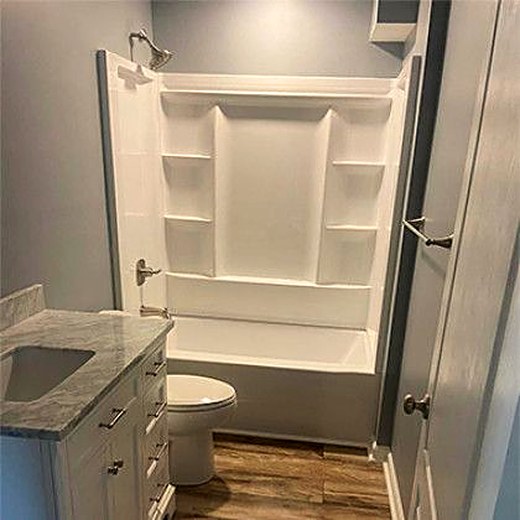 Finished bathroom with a tub-shower, toilet and vanity.
