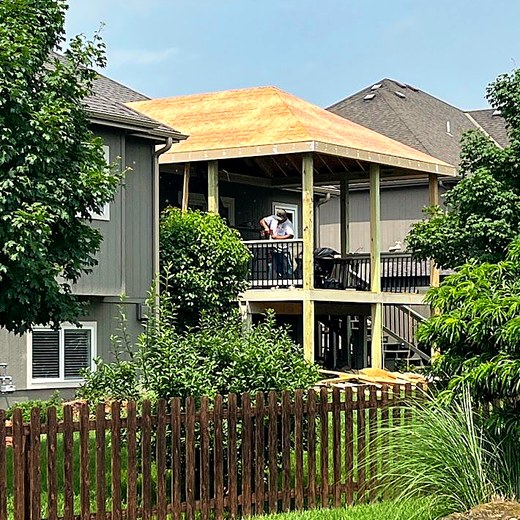 Screened porch with the roof sheathed and the structure enclosed.